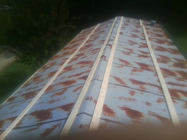 Rusted metal roof panels with new wood purlins before replacement — Storm Damage Roof Repair in Klemme by Roofing Brothers